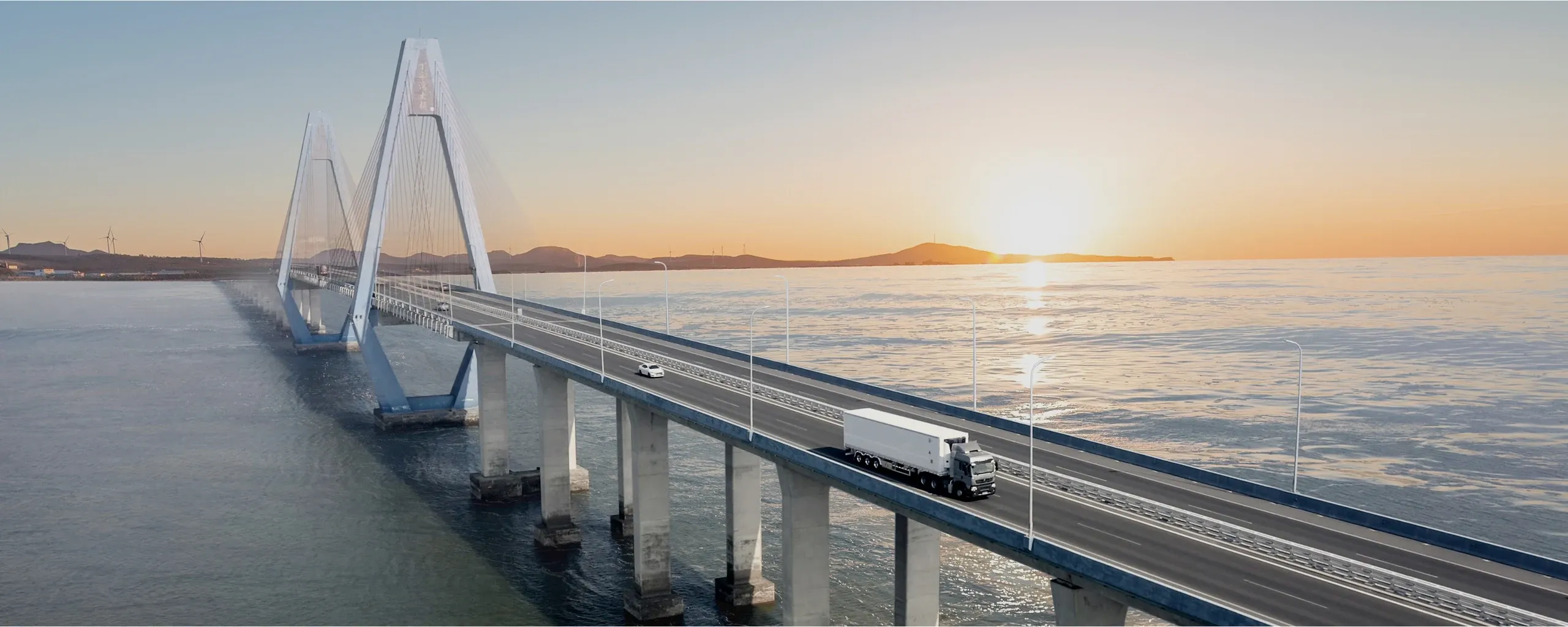 Camión SINOTRUK recorriendo un puente sobre el mar al amanecer